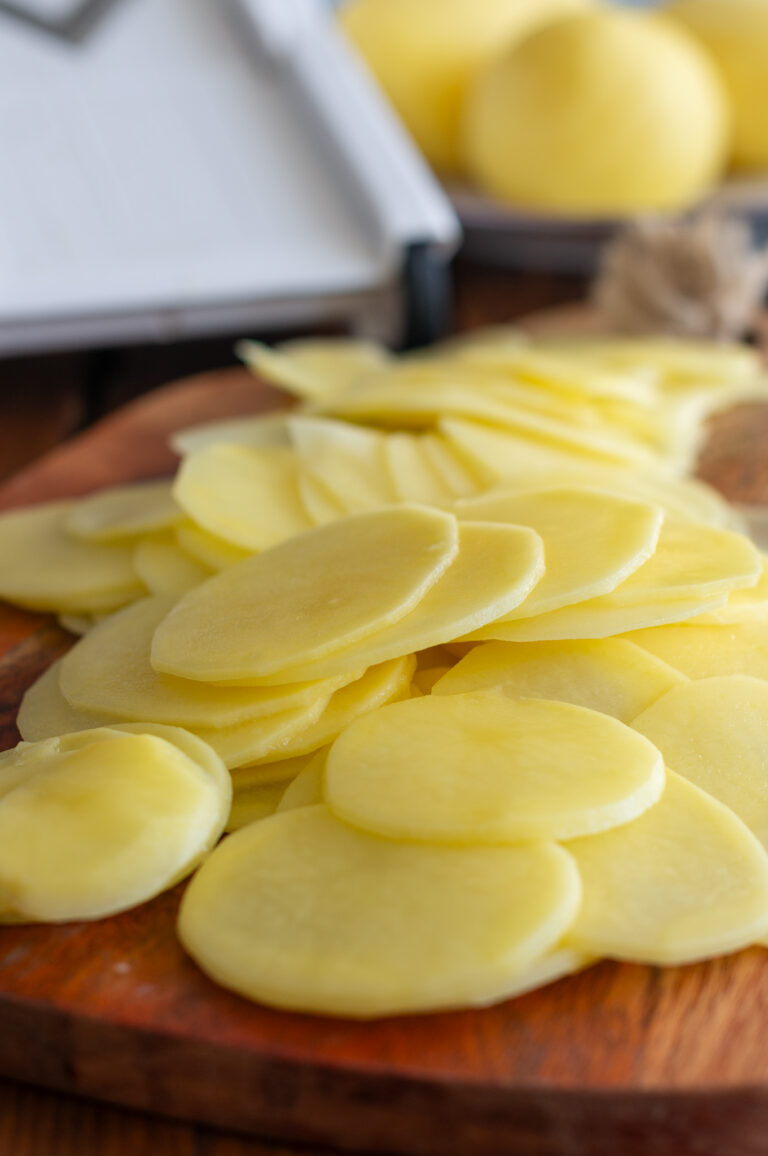 Cartofii tăiați felii subțiri pentru gratin Dauphinois